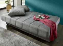 Frei im Raum aufstellbares Schlafsofa mit Dekokissen und Bettkasten