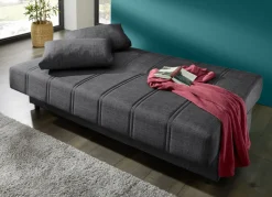 Frei im Raum aufstellbares Schlafsofa mit Dekokissen und Bettkasten