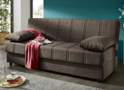 Frei im Raum aufstellbares Schlafsofa mit Dekokissen und Bettkasten